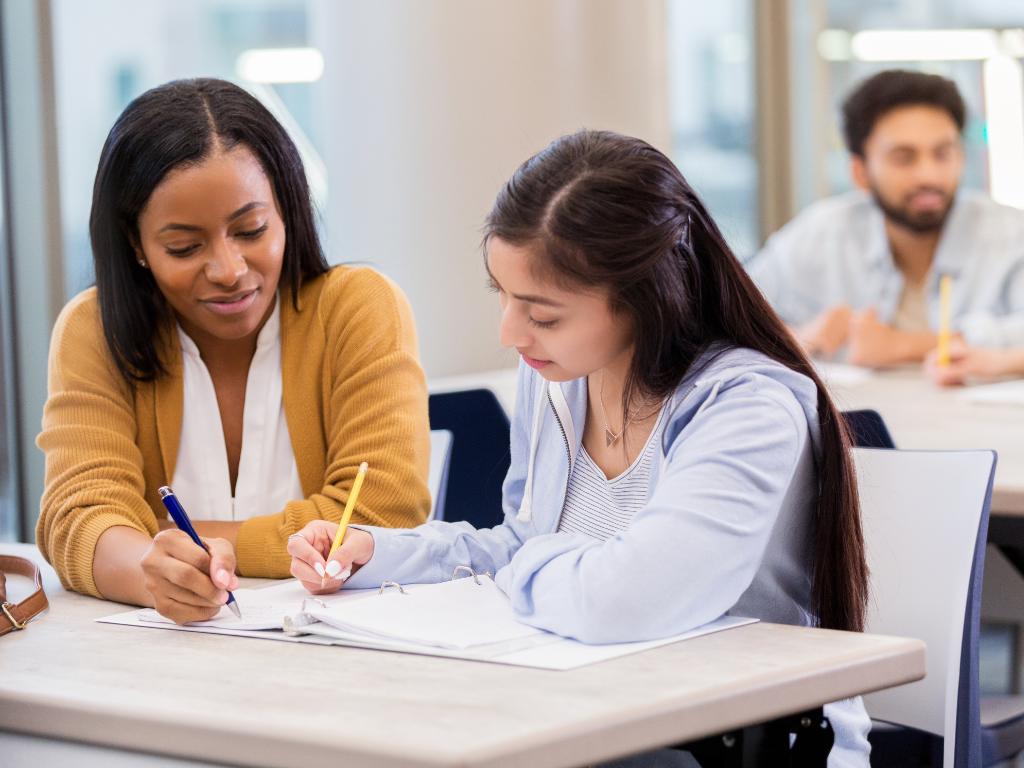 Tutor helping a student write during a learning session